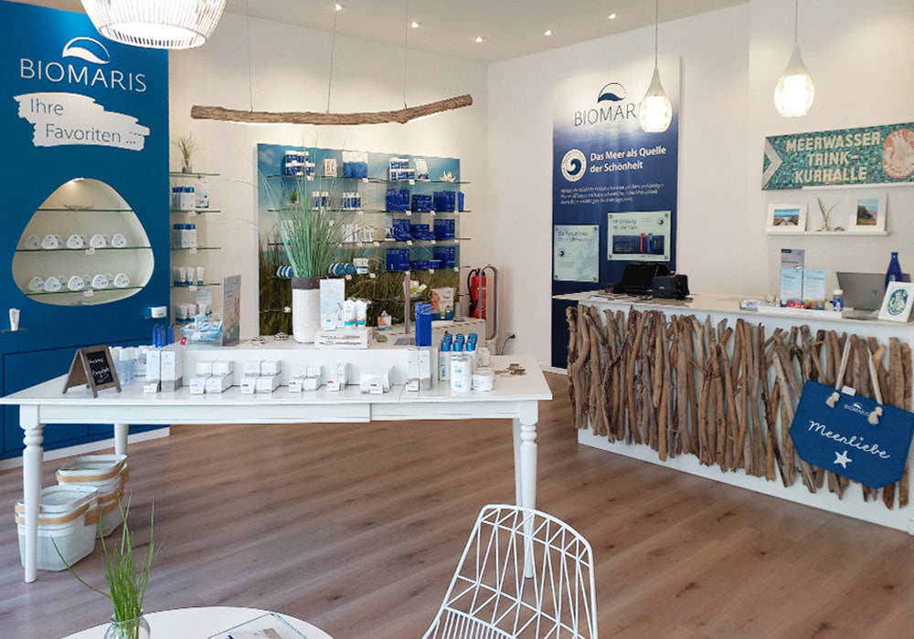 BIOMARIS Shop Heiligenhafen Innenansicht des BIOMARIS-Shops in Heiligenhafen mit Verkaufstheke aus Treibholz, Produktregalen und Werbetafeln