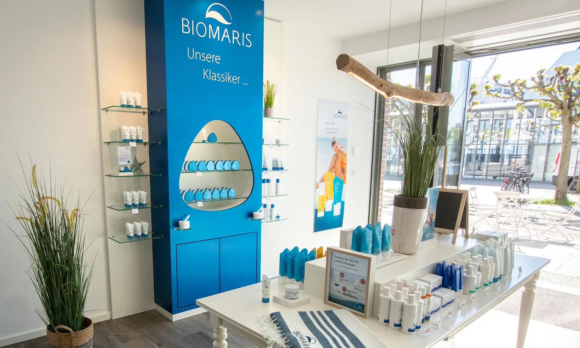 BIOMARIS Shop Travemünde Heller BIOMARIS-Shop in Travemünde mit blauem Markenauftritt, weißen Regalen und maritimer Einrichtung
