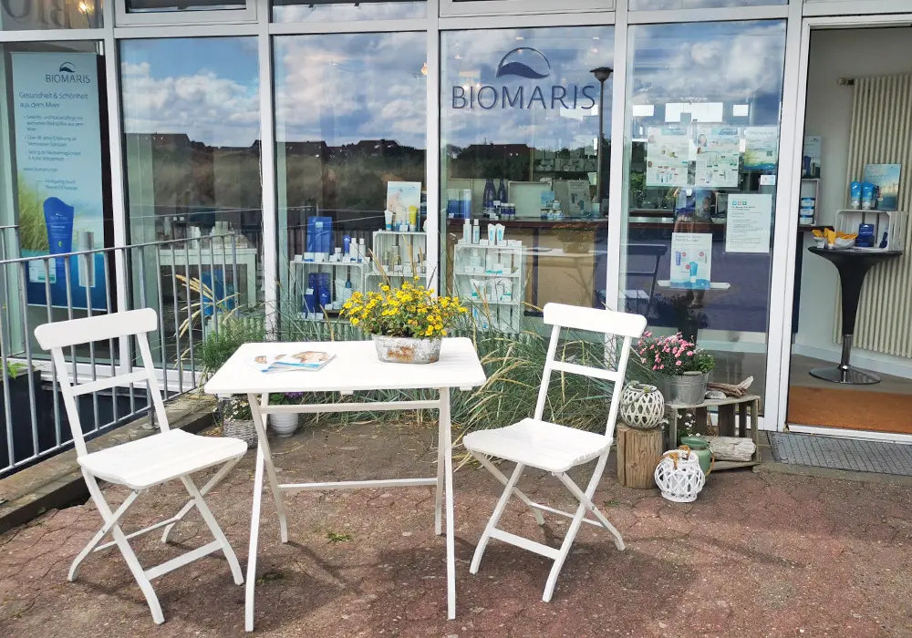 BIOMARIS Shop Baltrum Außenbereich des BIOMARIS-Shops auf Baltrum mit weißer Sitzgruppe und Schaufensterdeko
