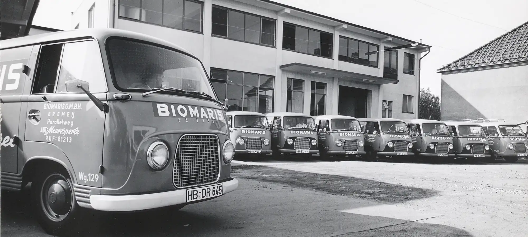 85 Jahre BIOMARIS Historische Aufnahme mit mehreren BIOMARIS Lieferwagen vor einem Firmengebäude