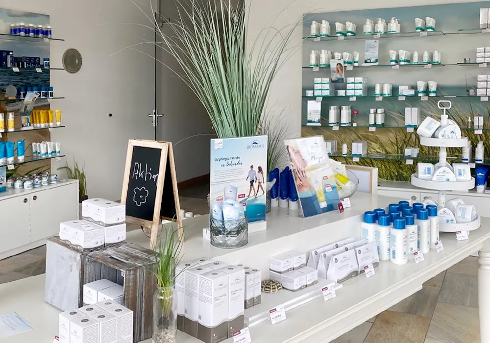 BIOMARIS Shop St. Peter-Ording Präsentationstisch mit Pflegeprodukten und Aufstellern, im Hintergrund Regale mit weiteren Produkten im BIOMARIS Shop