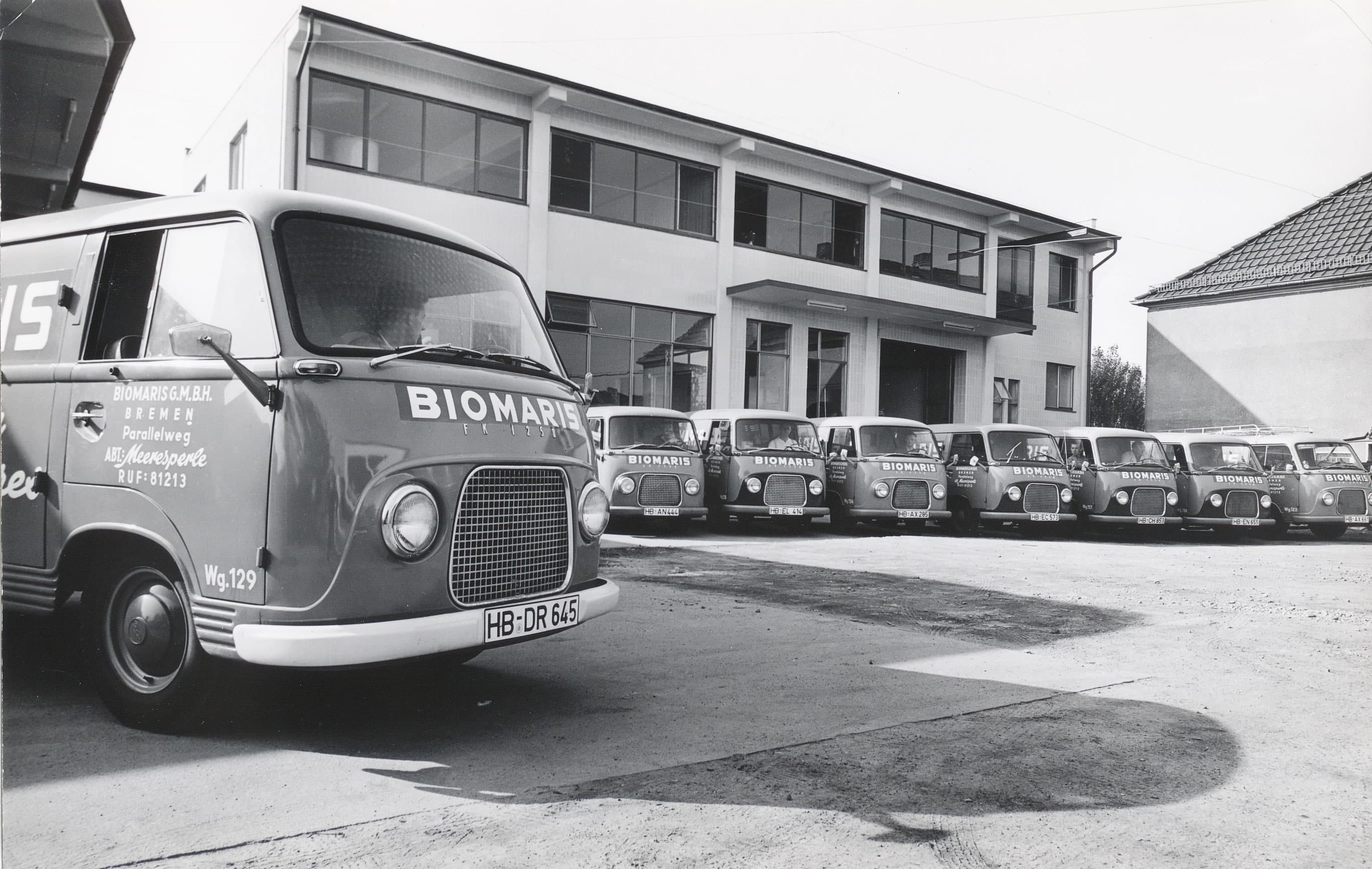 Biomaris Fuhrpark Historischer Fuhrpark von BIOMARIS vor dem Firmengebäude mit mehreren Lieferwagen